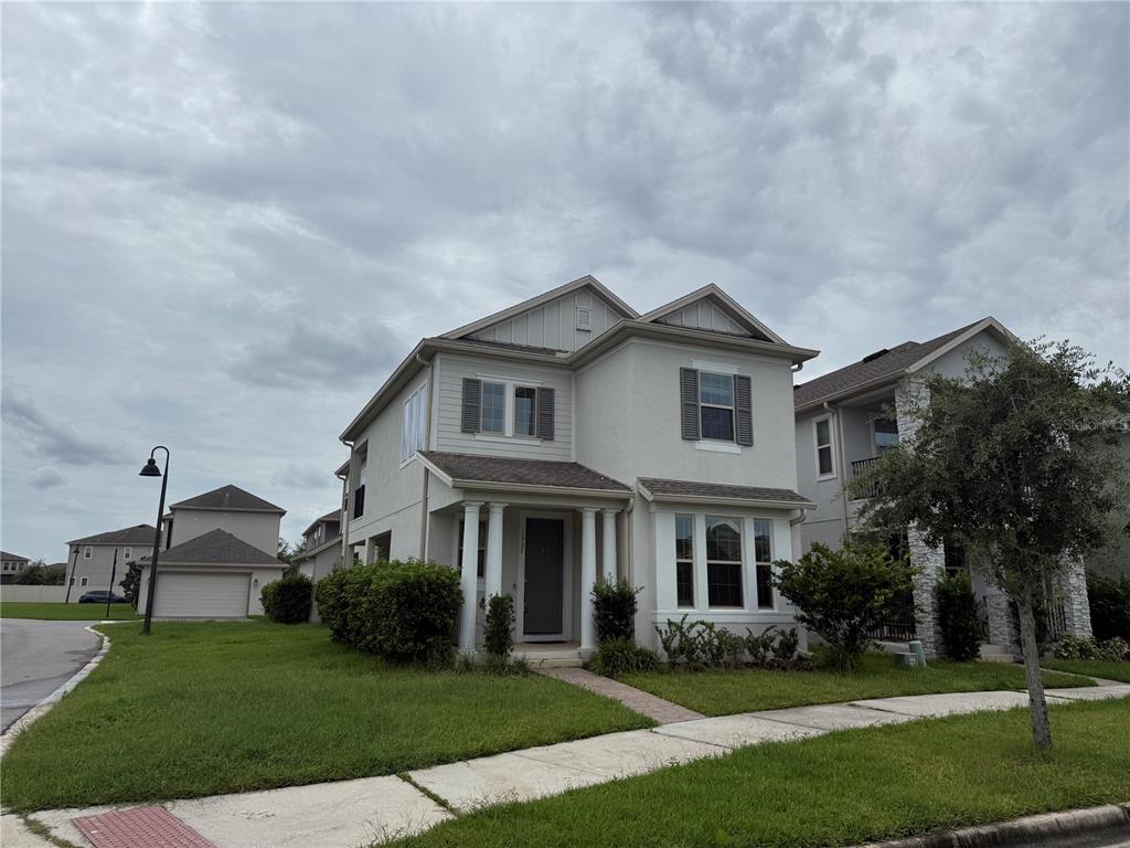 A two-story suburban house with a light-colored stucco exterior and a detached garage — 1337 SILVER MOON LANE, WINTER SPRINGS, FL