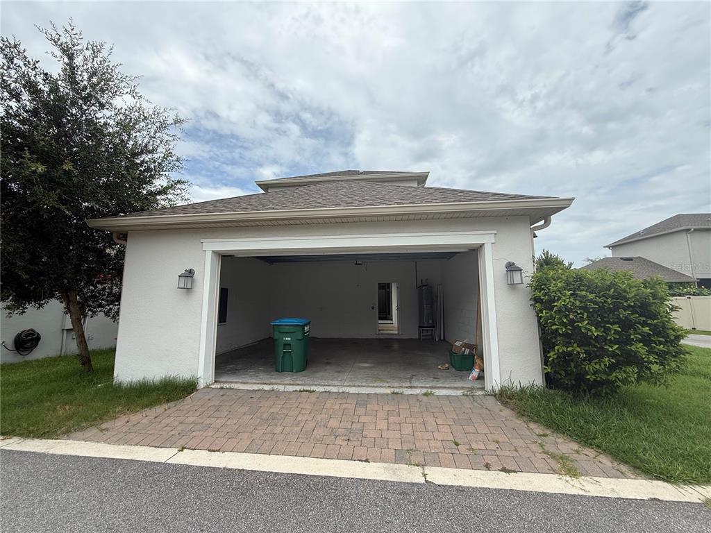 A detached garage with a paver driveway, a green trash bin, and a water heater — 1337 SILVER MOON LANE, WINTER SPRINGS, FL