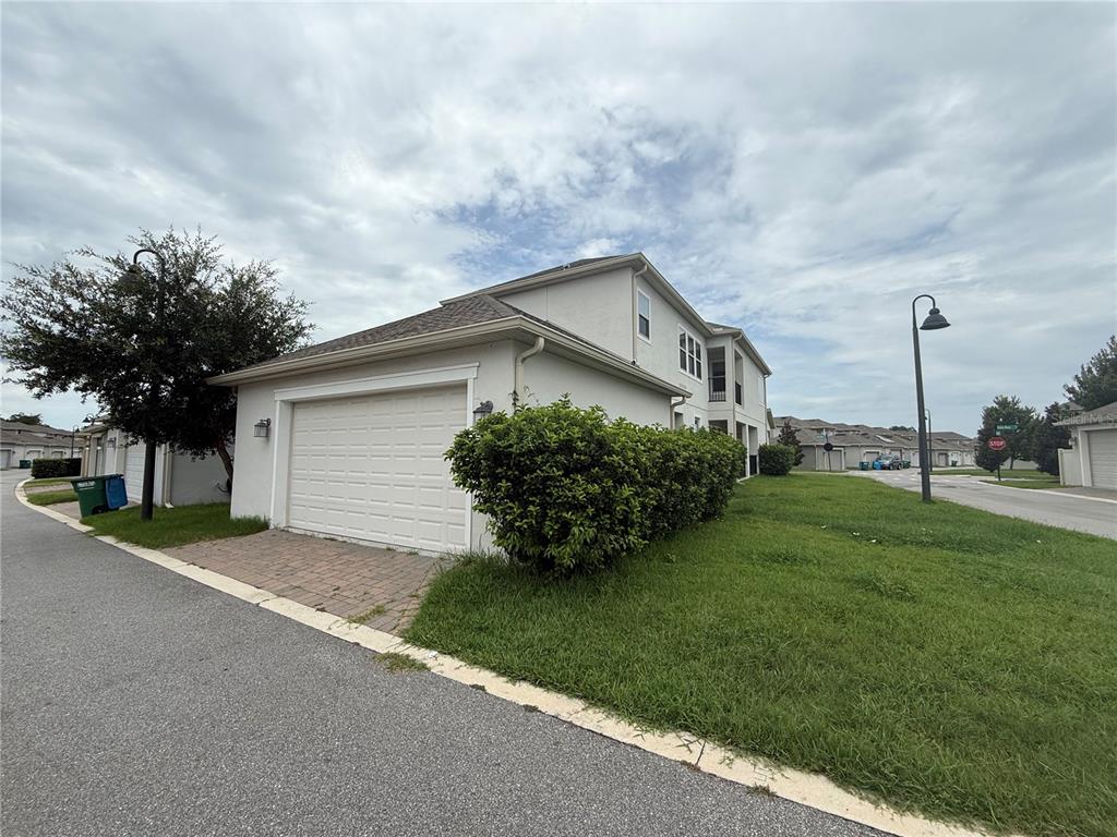 A two-story residential building with a white garage and a large green hedge — 1337 SILVER MOON LANE, WINTER SPRINGS, FL