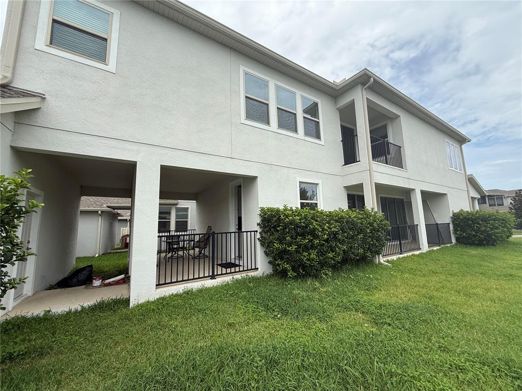 The exterior of a two-story stucco building features covered patios with black metal railings — 1337 SILVER MOON LANE, WINTER SPRINGS, FL