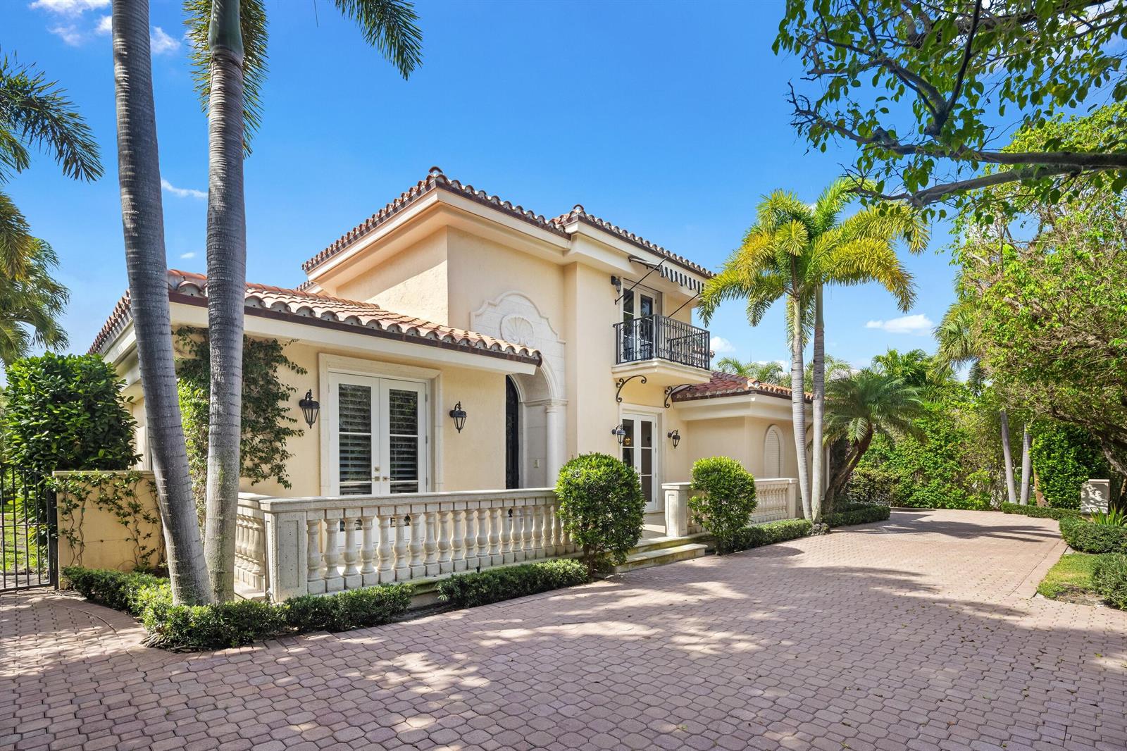 A two-story Mediterranean-style house with a paved driveway, balcony, and palm trees — 1460 N Ocean Boulevard, Palm Beach FL 33480, PALM BEACH, FL