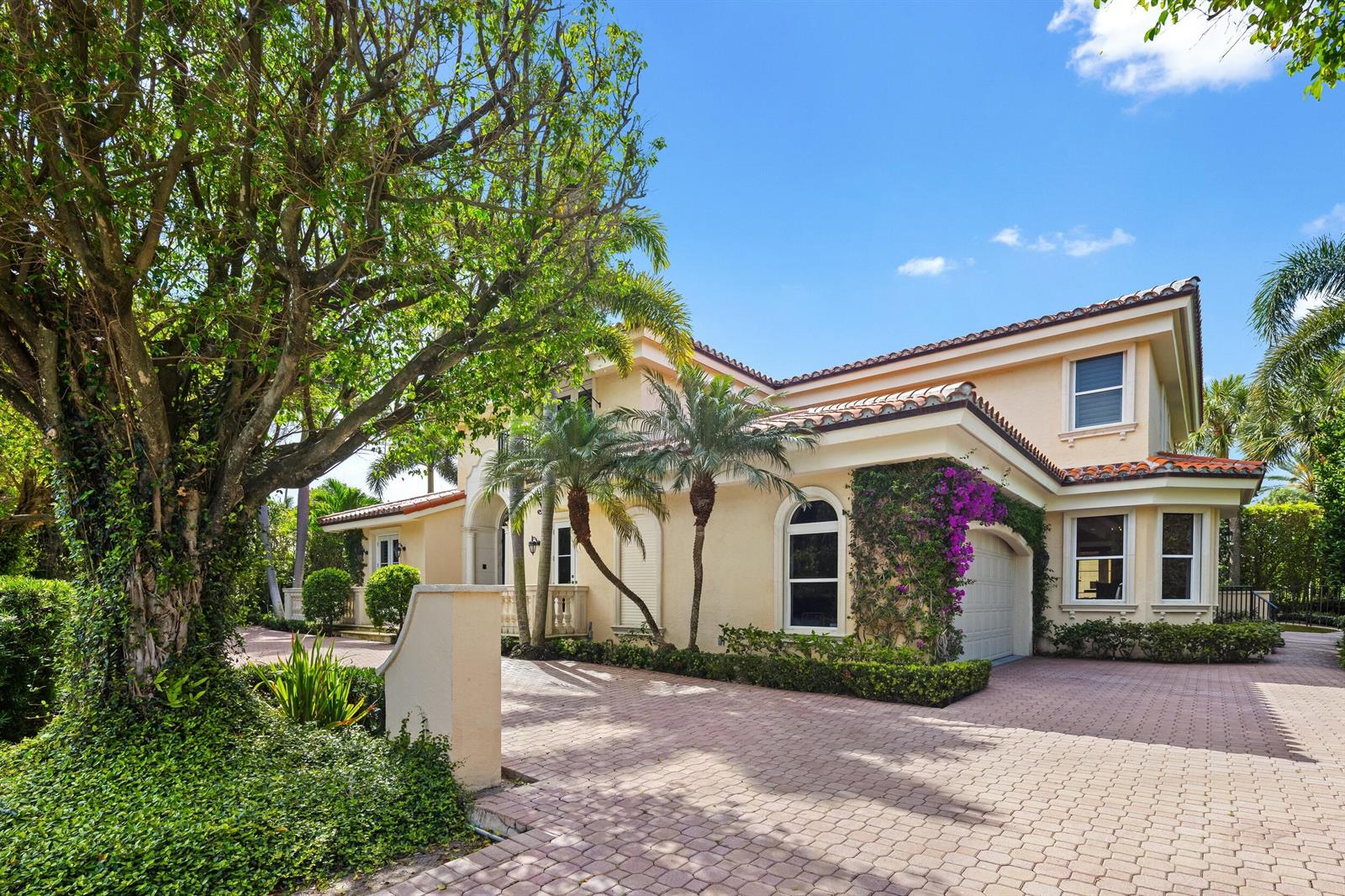 A two-story stucco house with a tiled roof and a paved driveway under a blue sky — 1460 N Ocean Boulevard, Palm Beach FL 33480, PALM BEACH, FL