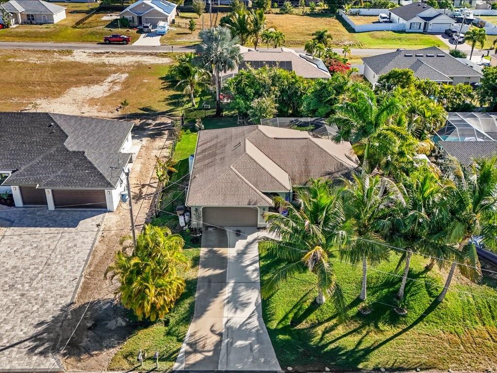An aerial view shows a single-story house with a brown roof and a concrete driveway — 1209 NW 25TH PLACE, CAPE CORAL, FL