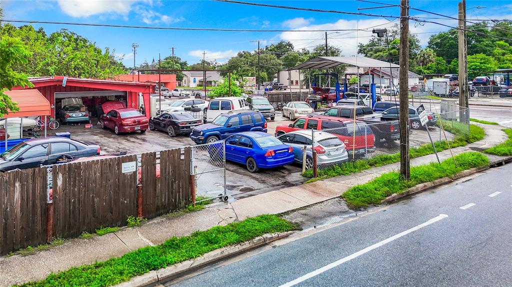 An outdoor auto repair shop features a covered service bay and multiple parked cars — 1412 E LAKE AVENUE, TAMPA, FL