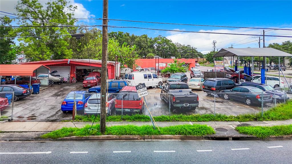 An exterior view of an automotive repair shop with multiple cars parked in the lot — 1412 E LAKE AVENUE, TAMPA, FL
