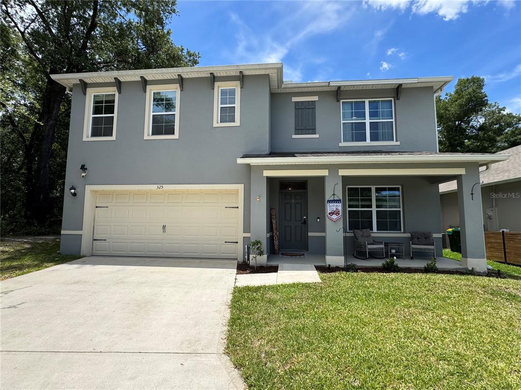A two-story gray house with a two-car garage and a covered front porch — 325 CHARLES DRIVE, DELAND, FL