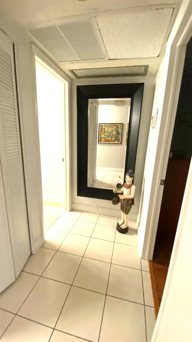 A tiled hallway features a large black-framed mirror and a decorative figurine — 2724 Garden S # 207, Lake Worth FL 33461, LAKE WORTH, FL