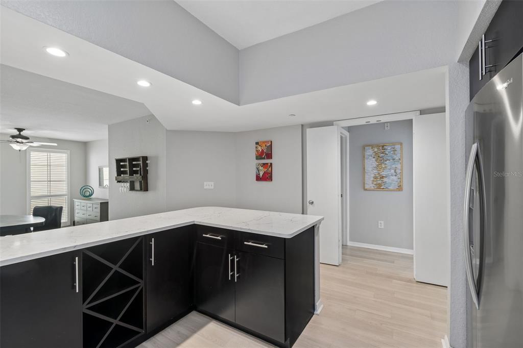 A kitchen island with dark cabinets and a white countertop sits in an open-concept room — 410 S ARMENIA AVENUE UNIT 929A, TAMPA, FL