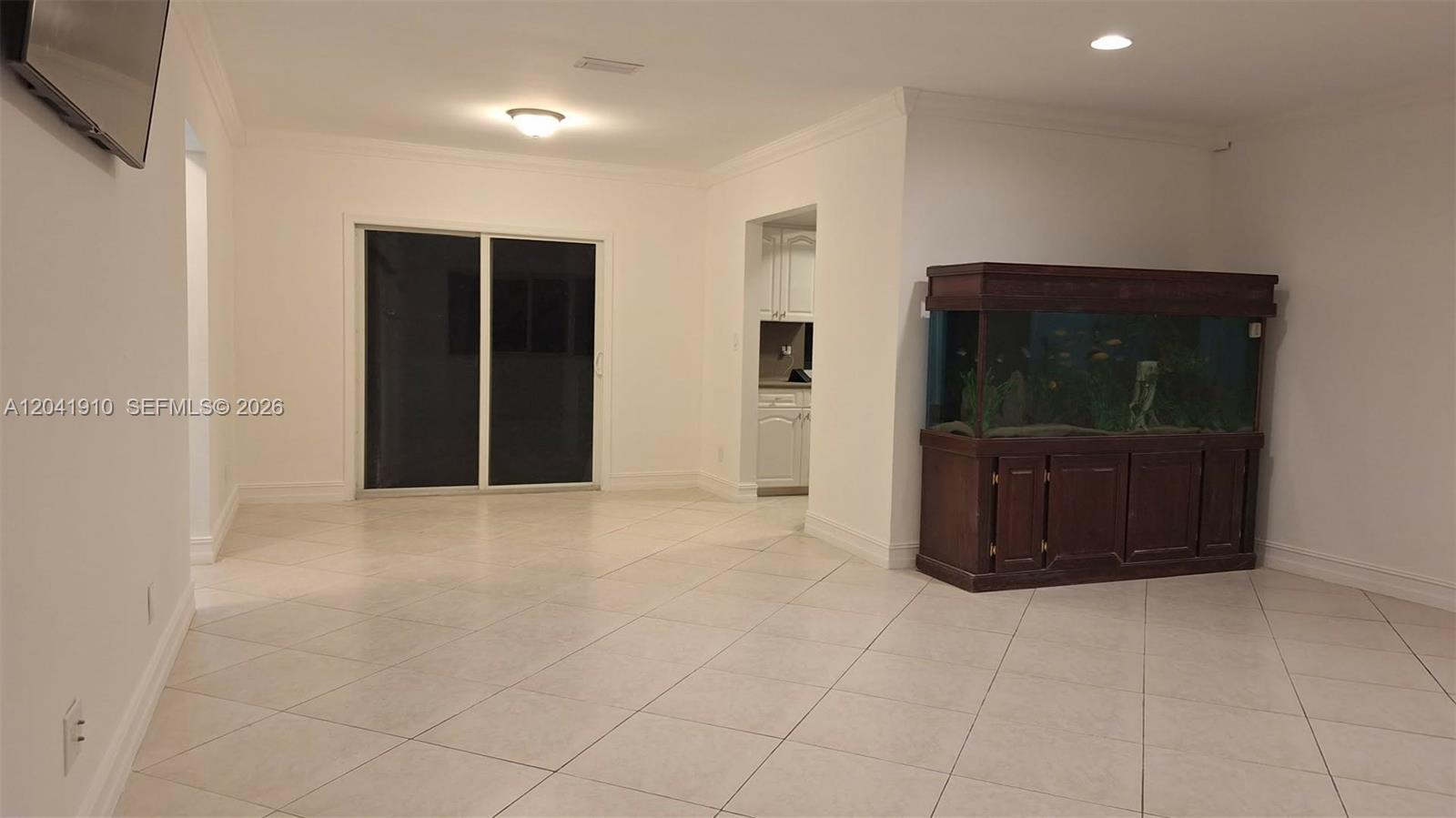 A room with white tile floors, a large fish tank, and a sliding glass door — 1800 N 55th Ave, Hollywood FL 33021, HOLLYWOOD, FL