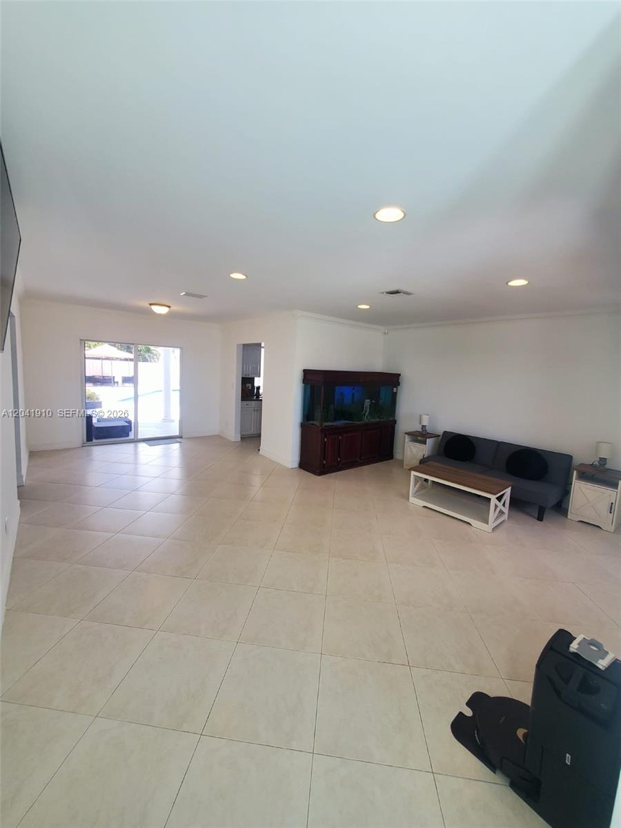 A spacious living room features light tile flooring, recessed lighting, and a large fish tank — 1800 N 55th Ave, Hollywood FL 33021, HOLLYWOOD, FL