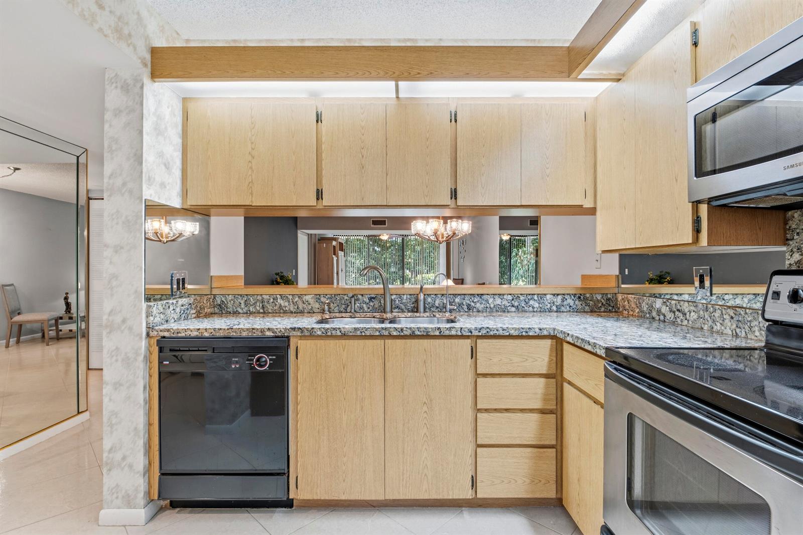 A kitchen with light wood cabinets, granite countertops, and stainless steel appliances — 6145 Balboa Circle # 103, Boca Raton FL 33433, BOCA RATON, FL