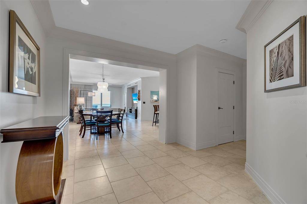 A tiled hallway leads to a dining area with a table and chairs — 915 SEASIDE DRIVE UNIT 611, SARASOTA, FL
