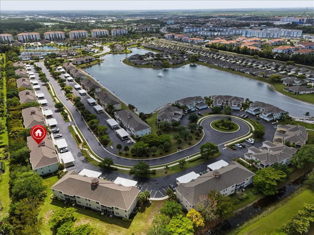 An aerial view shows a multi-story residential complex with a central lake and parking areas — 4223 LIRON AVENUE UNIT 104, FORT MYERS, FL