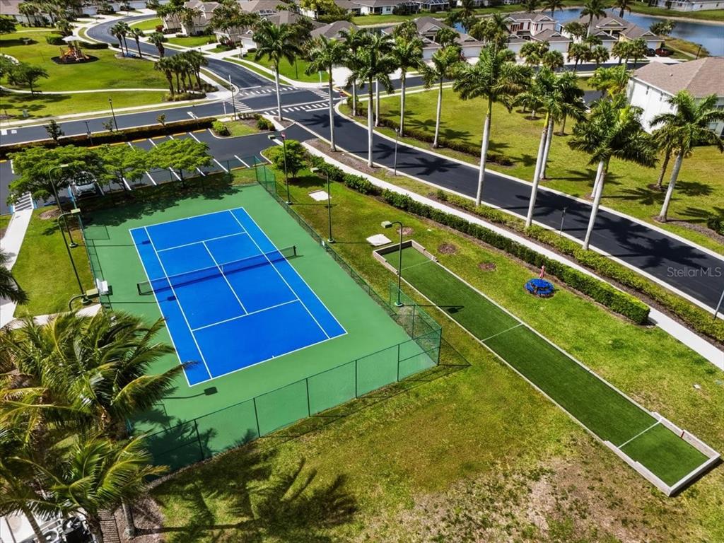 An aerial view of a blue tennis court and a bocce ball court outdoors — 4223 LIRON AVENUE UNIT 104, FORT MYERS, FL