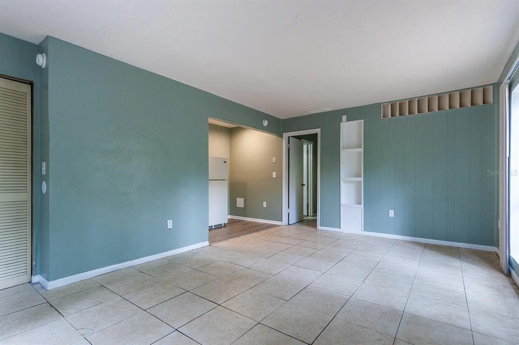 An interior view of a room with teal walls, tile flooring, and a built-in shelf — 409 NE 11TH STREET, GAINESVILLE, FL