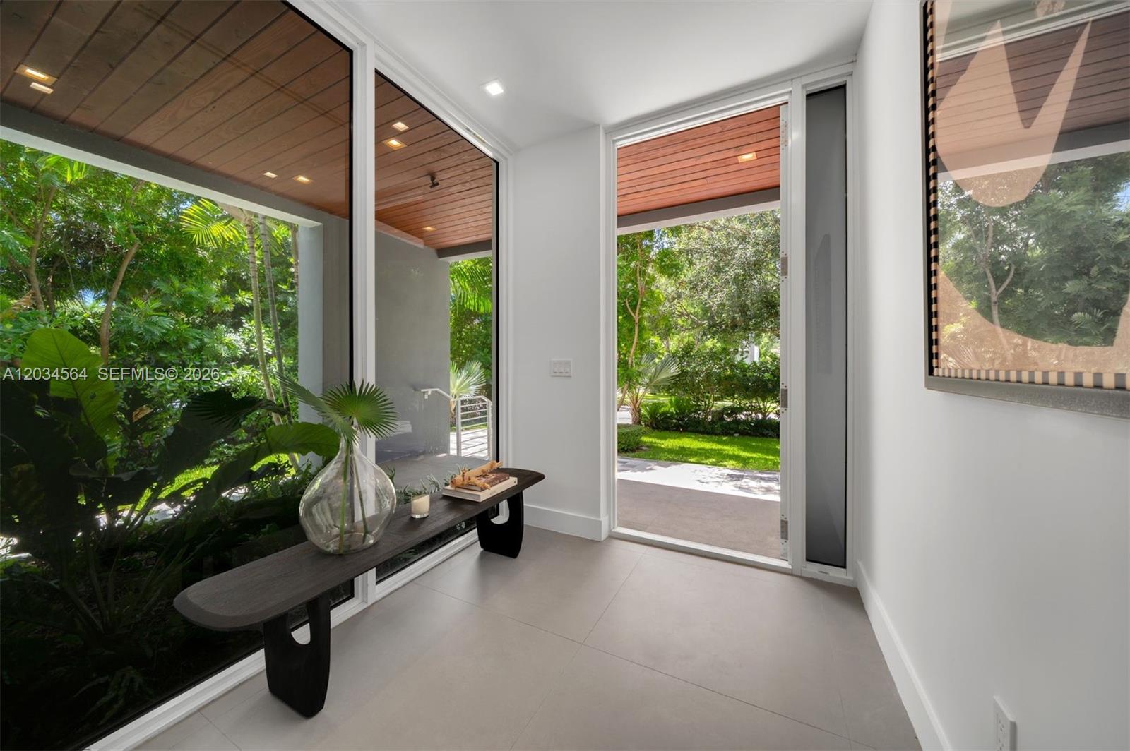 A modern entryway features large glass windows, a wooden ceiling, and a dark wooden bench — 425 Harbor Dr, Key Biscayne FL 33149, KEY BISCAYNE, FL