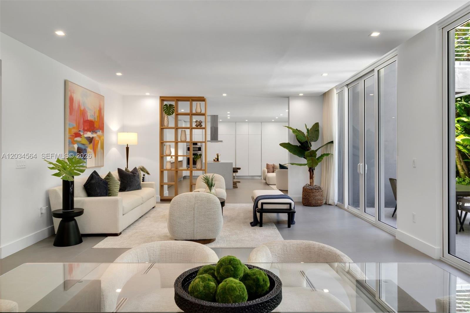 A bright, open-concept living area features a modern kitchen, wooden shelving, and glass sliding doors — 425 Harbor Dr, Key Biscayne FL 33149, KEY BISCAYNE, FL