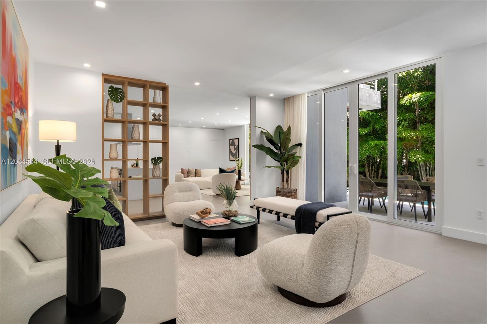 A modern living room features cream-colored furniture, a wooden room divider, and large glass doors — 425 Harbor Dr, Key Biscayne FL 33149, KEY BISCAYNE, FL