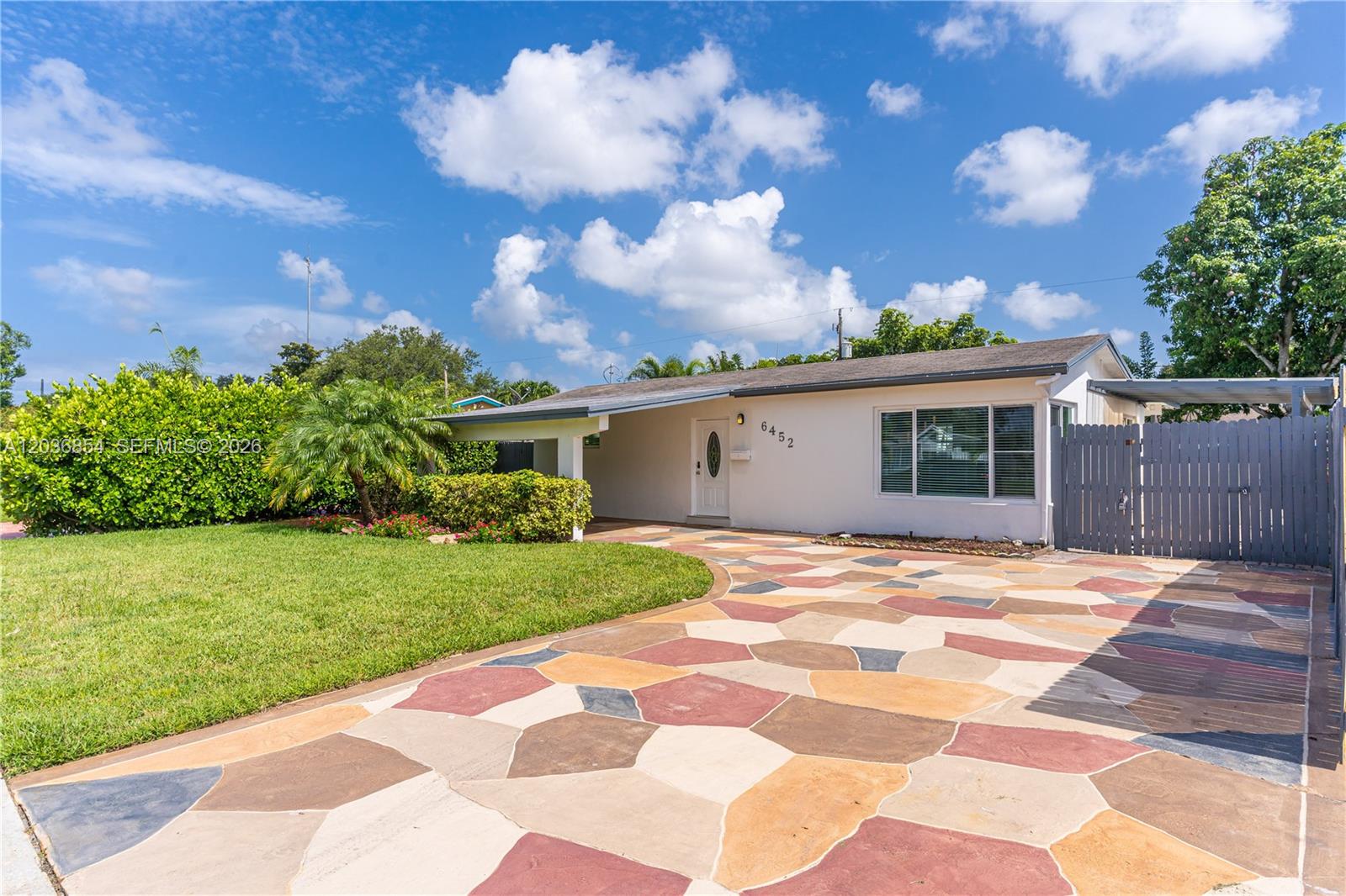 A single-story house features a multi-colored stone driveway and a white front door — 6452 Custer St, Hollywood FL 33024, HOLLYWOOD, FL