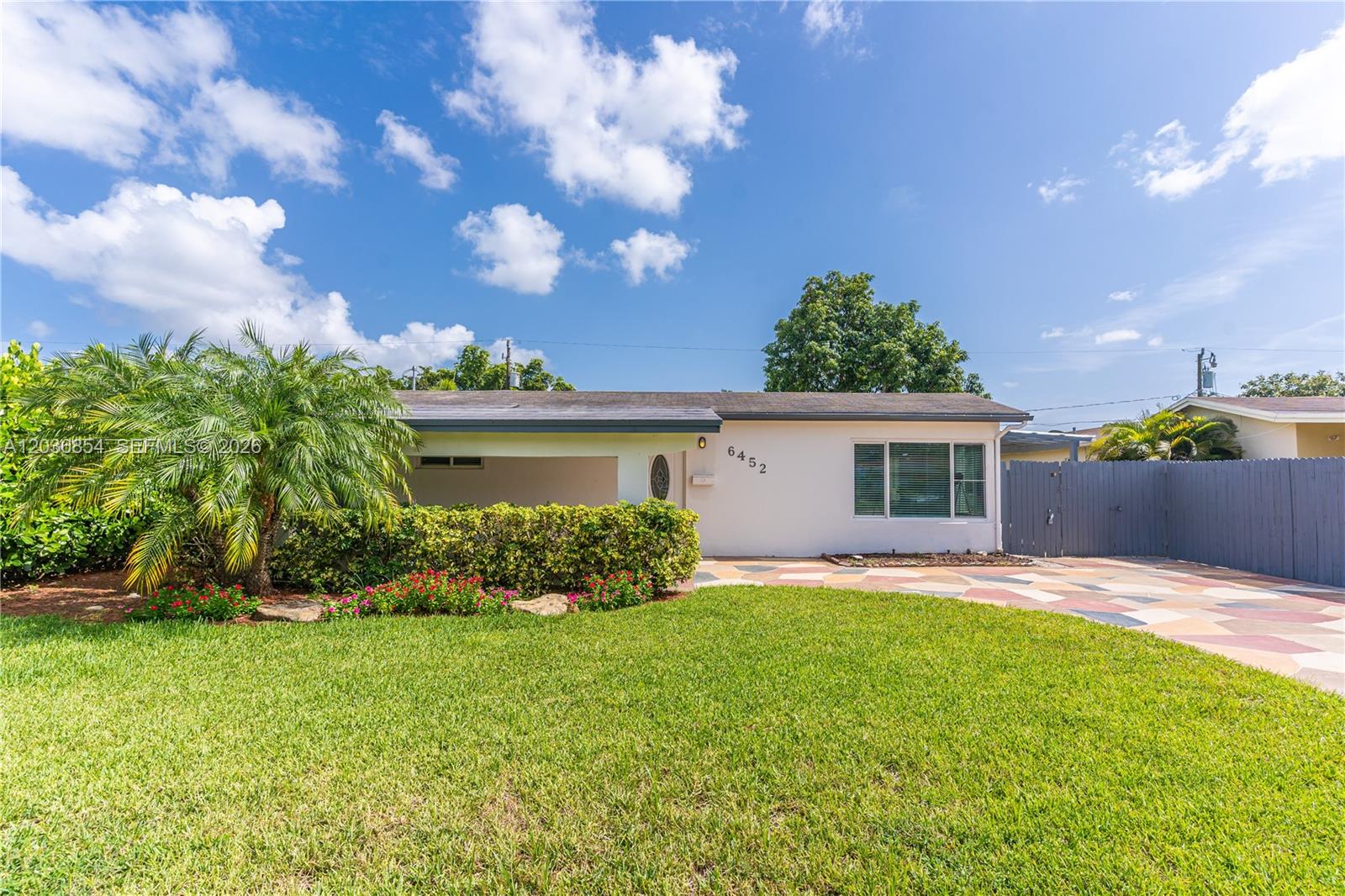 A single-story house features a palm tree, a manicured lawn, and a paved driveway — 6452 Custer St, Hollywood FL 33024, HOLLYWOOD, FL