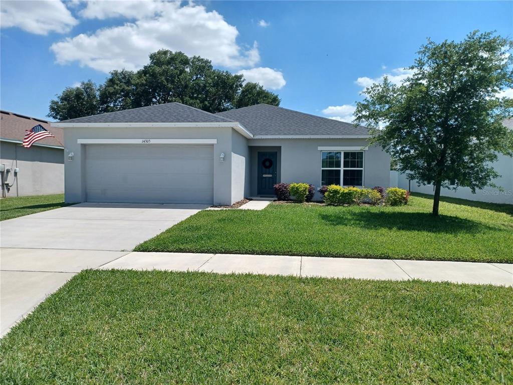 A single-story gray house with a two-car garage and a front lawn — 14305 HIDDEN COURT, CLERMONT, FL