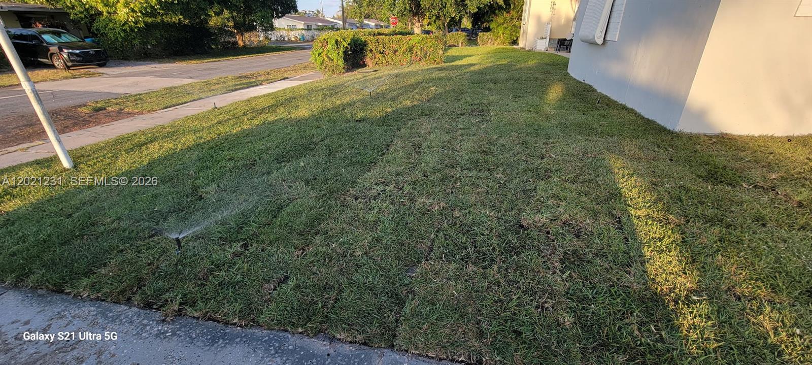 A residential lawn with an active sprinkler system sits beside the side of a house — 142 SE 4th ave, Boynton Beach FL 33435, BOYNTON BEACH, FL