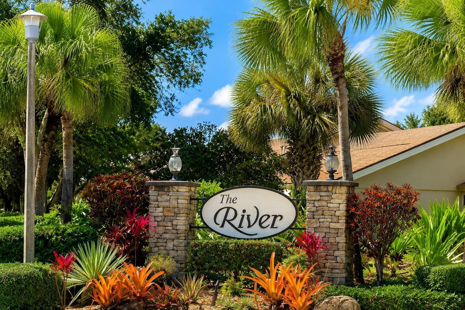 An oval sign reading The River stands between two stone pillars surrounded by tropical landscaping — 154 Sandbar Drive, Jupiter FL 33477, JUPITER, FL
