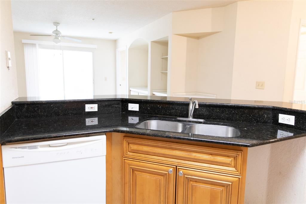 A kitchen sink with a dark granite countertop and light wood cabinets — 822 CAMARGO WAY UNIT 208, ALTAMONTE SPRINGS, FL