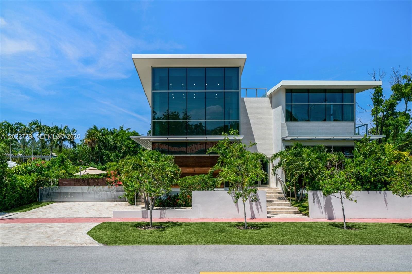 A modern two-story house with a large glass facade, flat roof, and landscaped front yard — 1201 W 47th St, Miami Beach FL 33140, MIAMI BEACH, FL