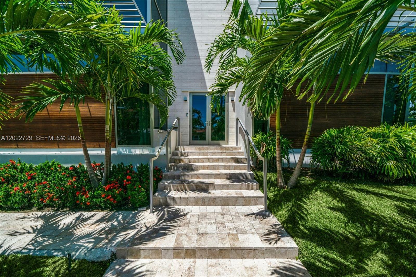 A stone staircase leads to the glass double-door entrance of a modern home with palms — 1201 W 47th St, Miami Beach FL 33140, MIAMI BEACH, FL