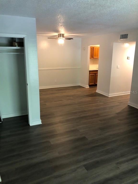 An interior view shows a room with wood-look flooring, a ceiling fan, and a closet — 6519 W NEWBERRY ROAD UNIT 507, GAINESVILLE, FL