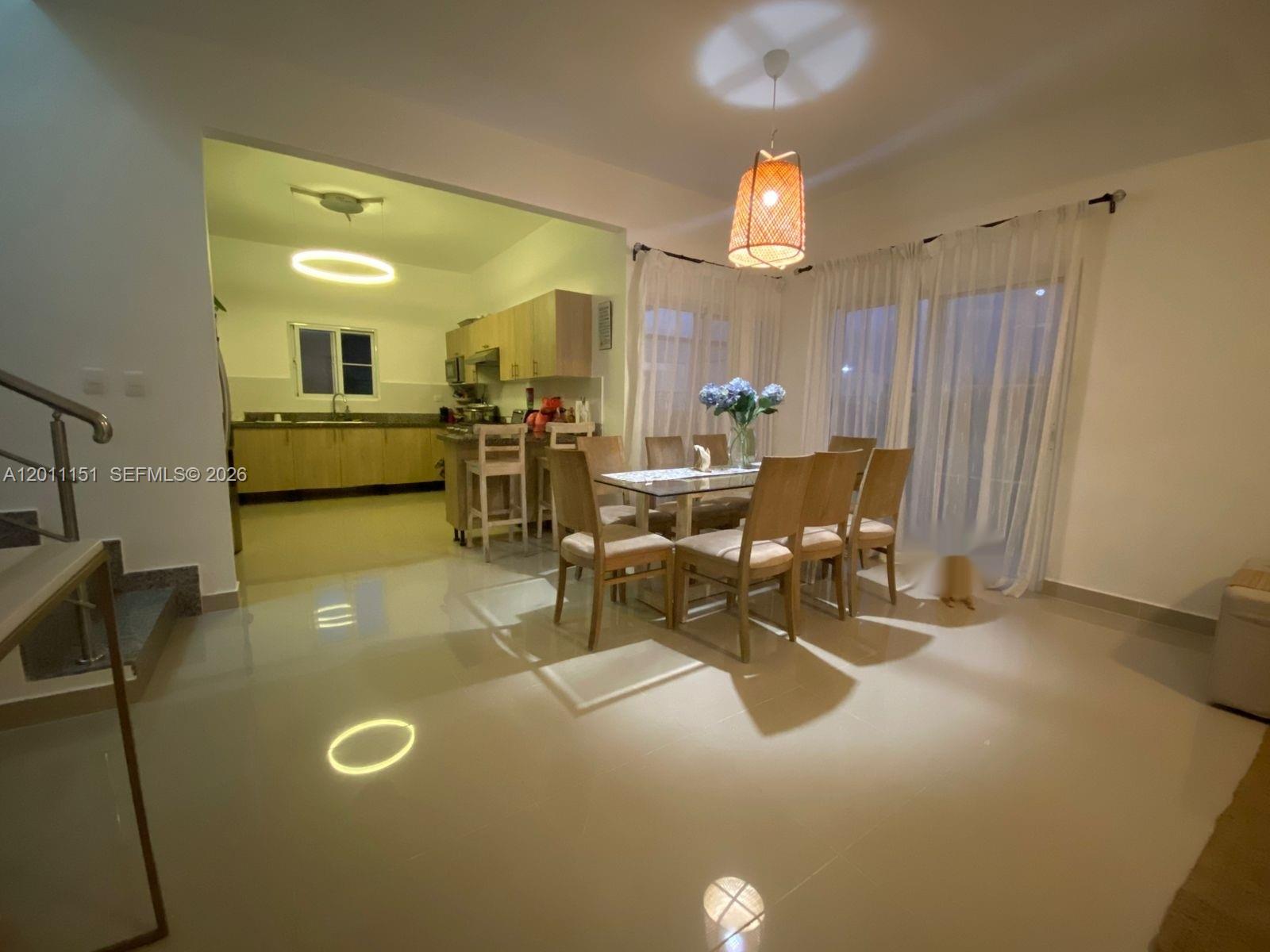 A dining area with a glass table and chairs sits adjacent to an open kitchen — M.71 Ciudad La Palma Dominican Republic, FL