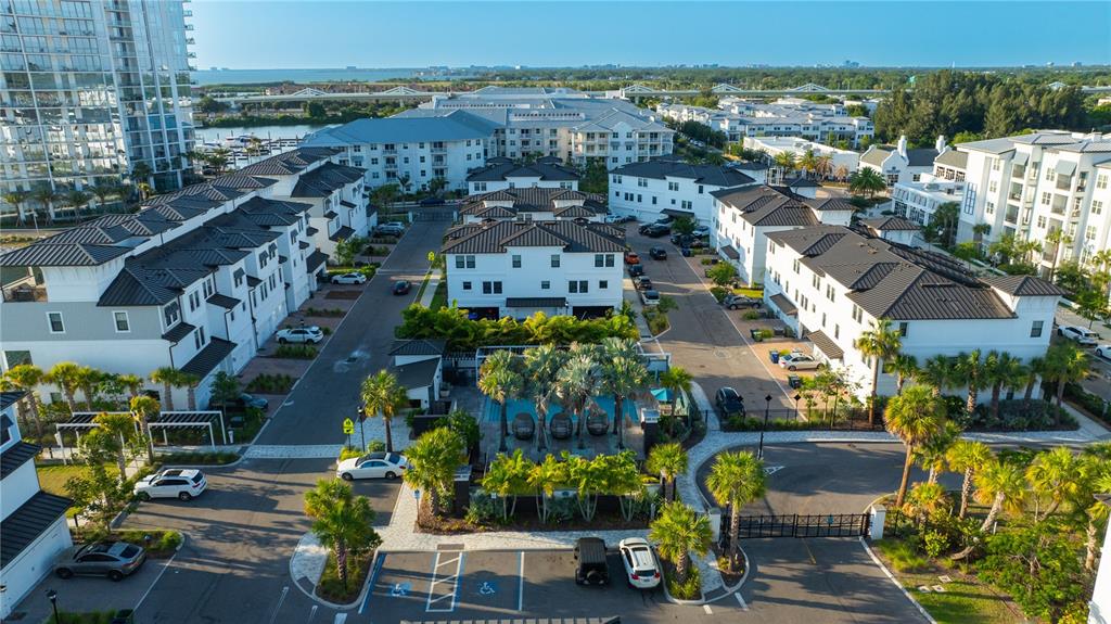 A row of three-story white townhomes with attached garages and paved driveways — 5351 BRIDGE STREET UNIT 62, TAMPA, FL