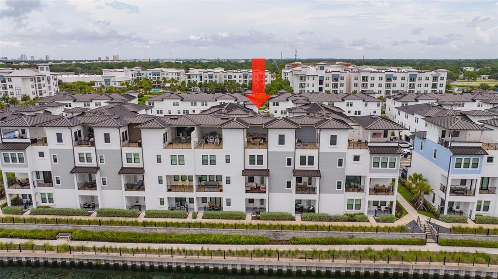 An aerial view shows a residential complex with townhouses, a swimming pool, and parking areas — 5351 BRIDGE STREET UNIT 62, TAMPA, FL