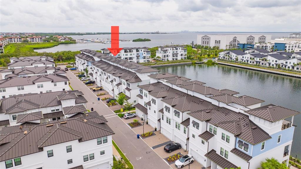 An aerial view of a multi-story apartment complex with a red arrow pointing toward it — 5351 BRIDGE STREET UNIT 62, TAMPA, FL