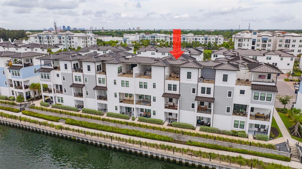 An aerial view of a row of modern townhouses situated along a waterfront canal — 5351 BRIDGE STREET UNIT 62, TAMPA, FL