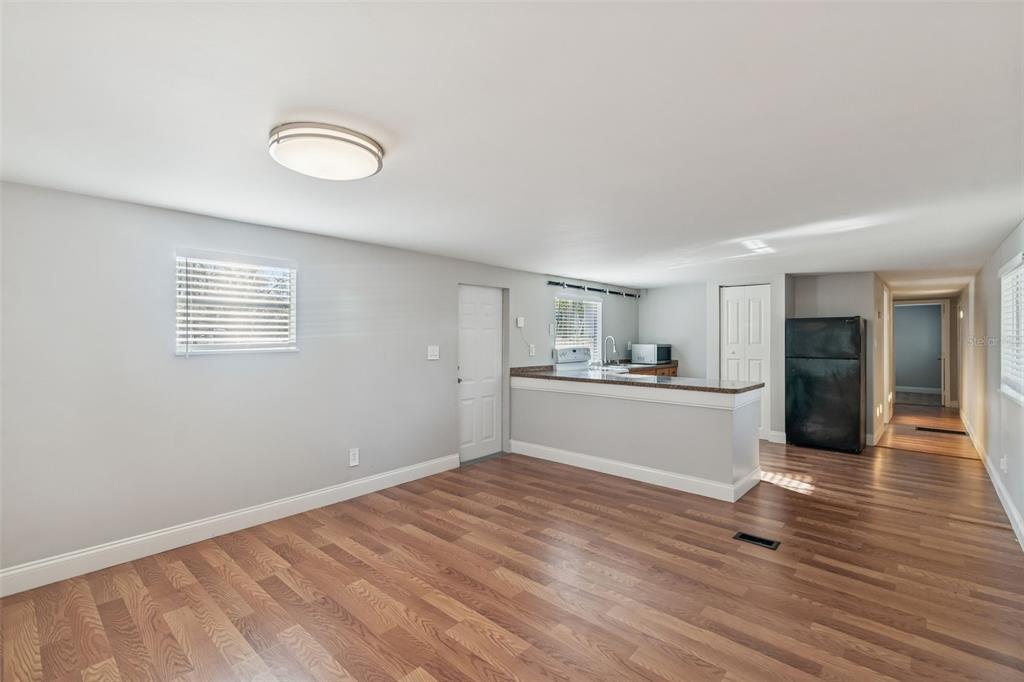 A living room with wood-look flooring leads to an open kitchen with a breakfast bar — 5464 S WILSON POINT, HOMOSASSA, FL