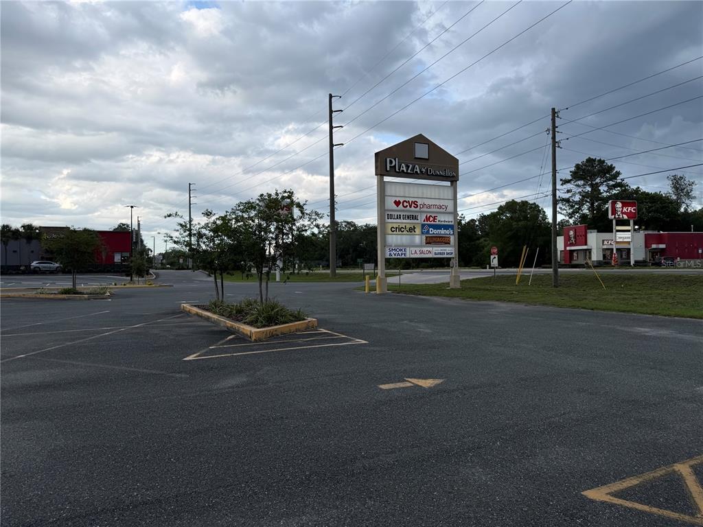 A parking lot leads to a shopping plaza sign and a nearby KFC restaurant — 11582 N WILLIAMS STREET, DUNNELLON, FL