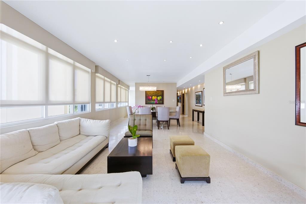 A bright living and dining area with white tile floors, a sectional sofa, and furniture — 1115 PICCIONI UNIT 3A, SAN JUAN, PR