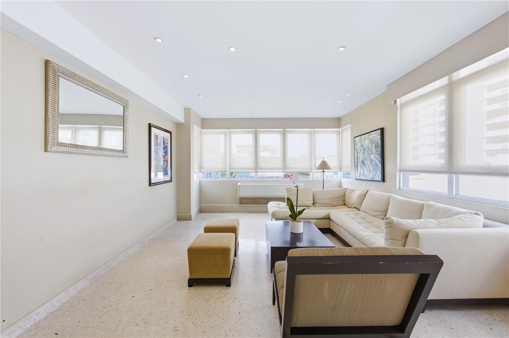 A living room features a white sectional sofa, two ottomans, and light-colored terrazzo flooring — 1115 PICCIONI UNIT 3A, SAN JUAN, PR