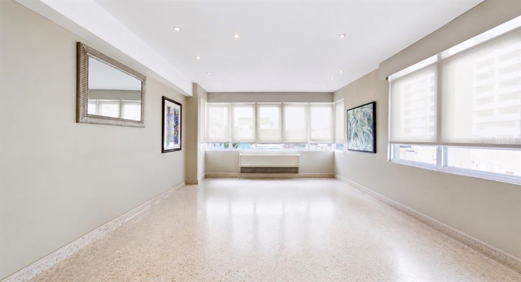 An empty room with light-colored walls, terrazzo flooring, recessed lighting, and large windows — 1115 PICCIONI UNIT 3A, SAN JUAN, PR