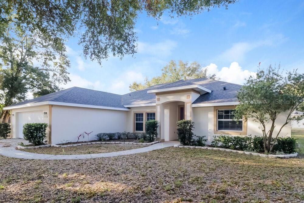A single-story house with a beige stucco exterior, a gray roof, and a paved walkway — 426 DISSTON AVENUE, CLERMONT, FL