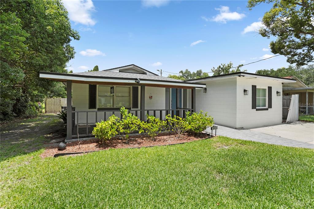 A single-story house with white siding, a covered front porch, and a paved driveway — 2412 GRANDVIEW AVENUE, SANFORD, FL
