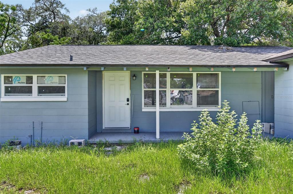 A single-story house with light blue siding, a white front door, and a covered porch — 116 S GLENWOOD AVENUE, ORLANDO, FL