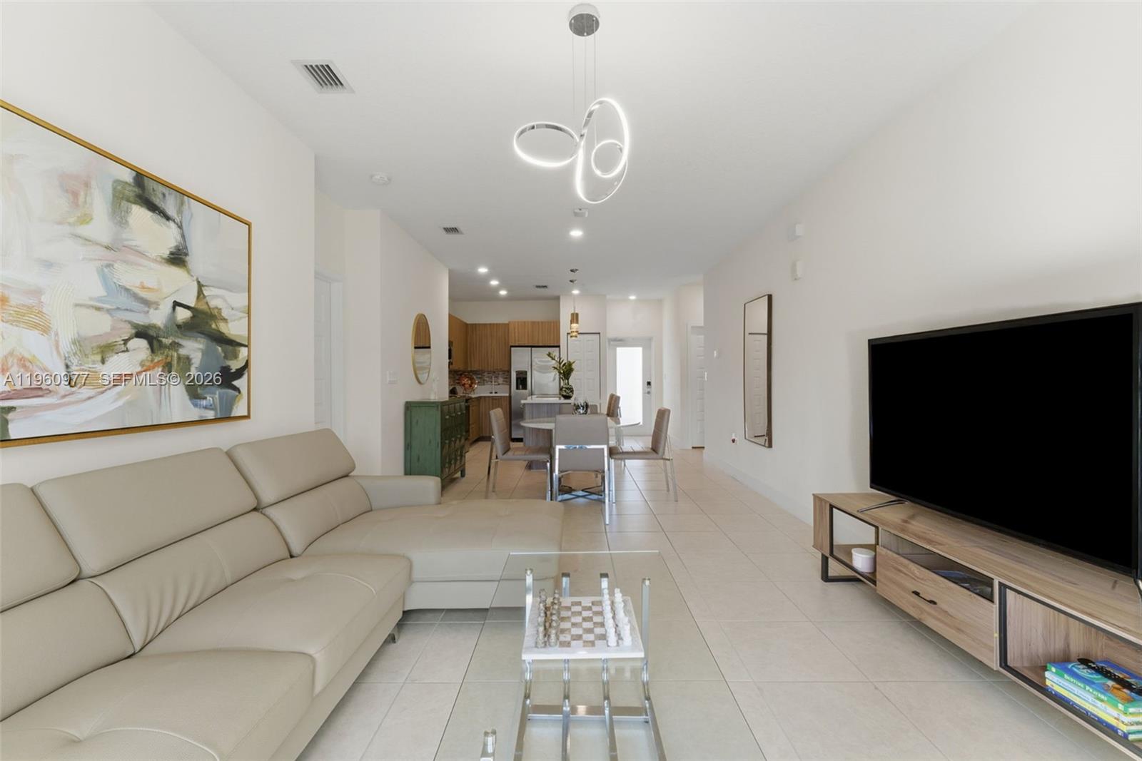 A living room features a beige sectional sofa, a television console, and a dining area — 8301 NW 41st St # 407, Doral FL 33166, DORAL, FL