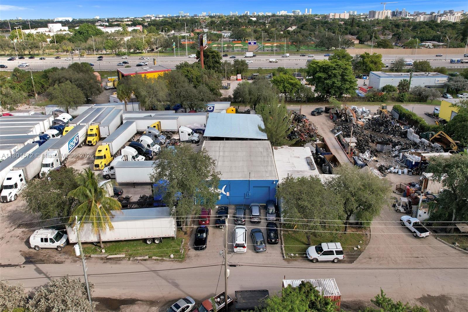 An aerial view shows a commercial property with a warehouse, parked trucks, and a salvage yard — 850 NW 12th Ter, Pompano Beach FL 33069, POMPANO BEACH, FL