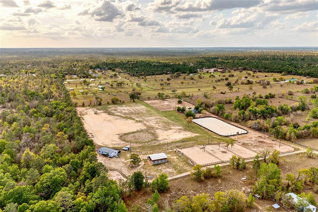 An aerial view shows a rural property with a house, outbuildings, and horse riding arenas — 16170 SW 30TH LANE, OCALA, FL