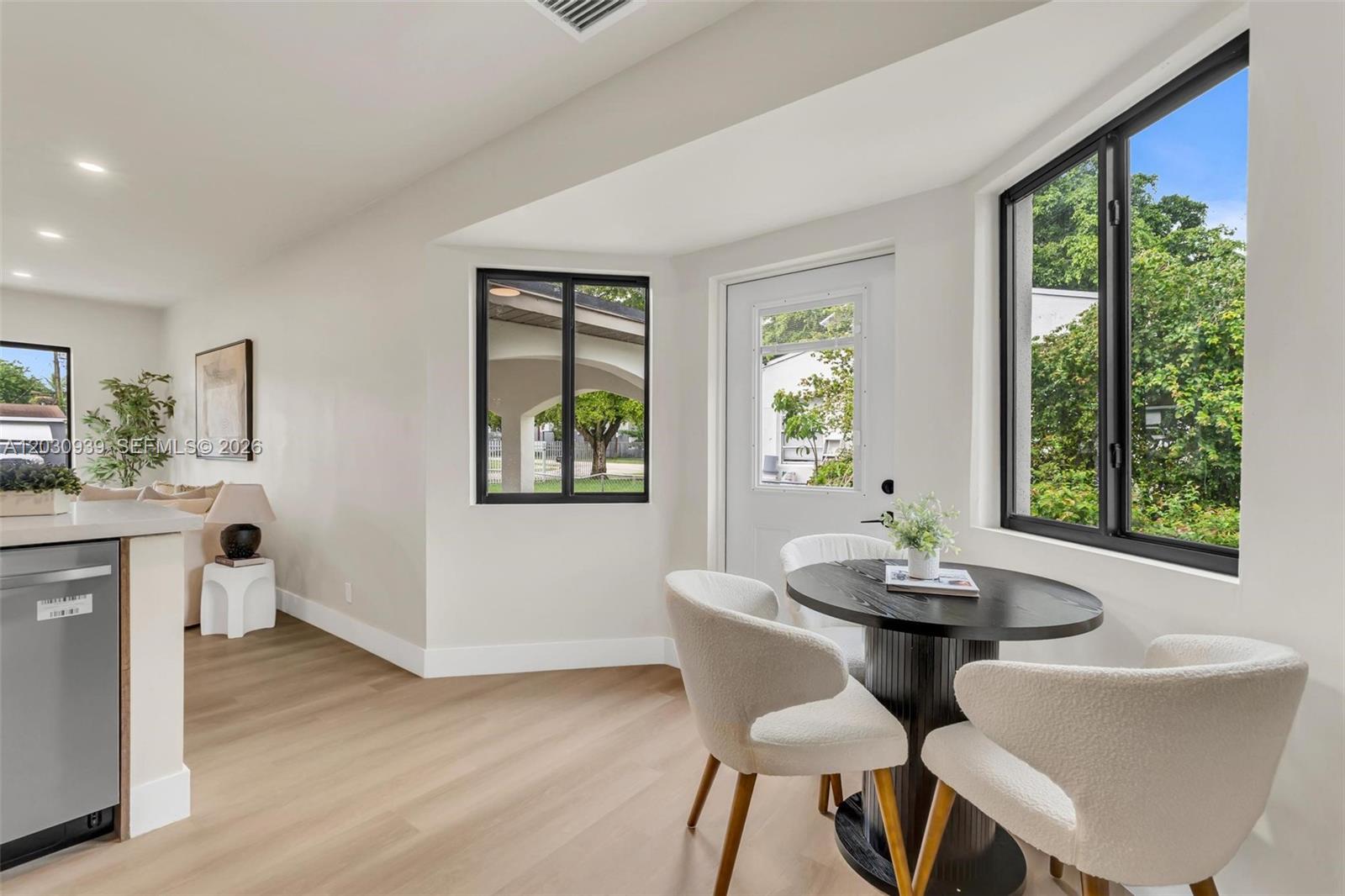 A bright dining nook features a round table, white chairs, and a glass-paneled door — 2651 Fletcher Ct, Hollywood FL 33020, HOLLYWOOD, FL