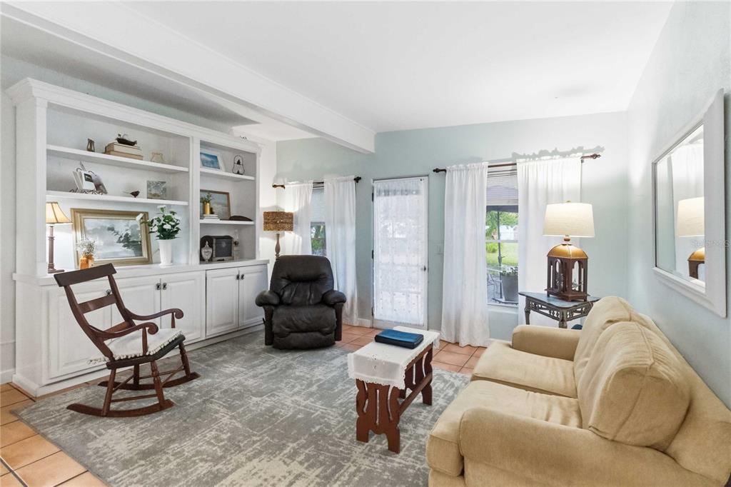 A living room features a white built-in bookshelf, a rocking chair, a recliner, and sofa — 407 S SUNLAND DRIVE, SANFORD, FL