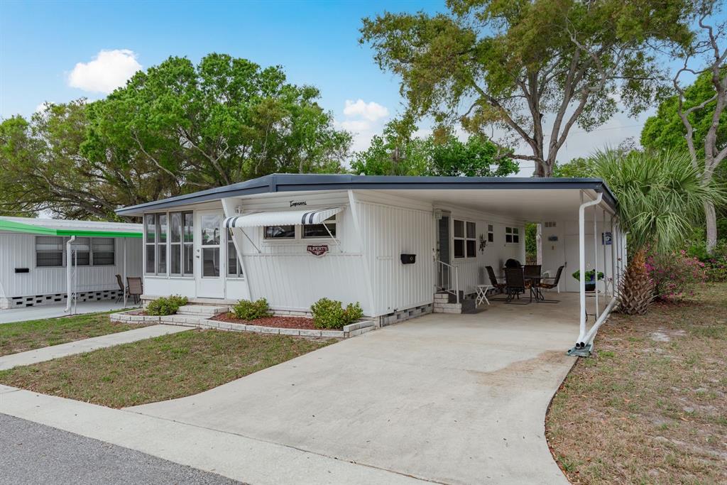 A white single-wide mobile home with a carport and a small front yard — 2331 BELLEAIR ROAD UNIT 514, CLEARWATER, FL